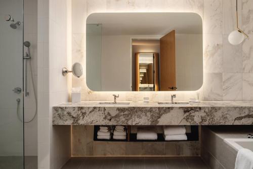 a bathroom with two sinks and a large mirror at The Loren at Lady Bird Lake in Austin