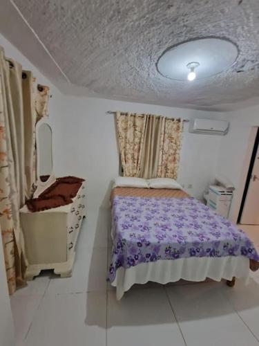 a small bedroom with a bed and a dresser at Cozy 2 bed in Ocho Rios in Ocho Rios