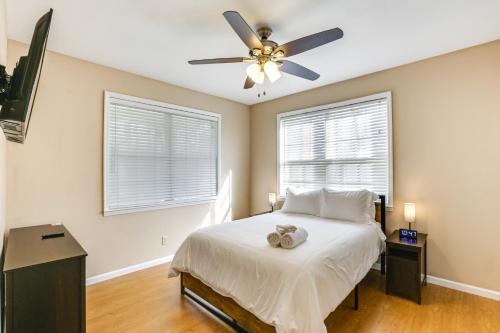 um quarto com uma cama, uma ventoinha de tecto e 2 janelas em Bainbridge Home with Cove and Lake Seminole Access! em Bainbridge