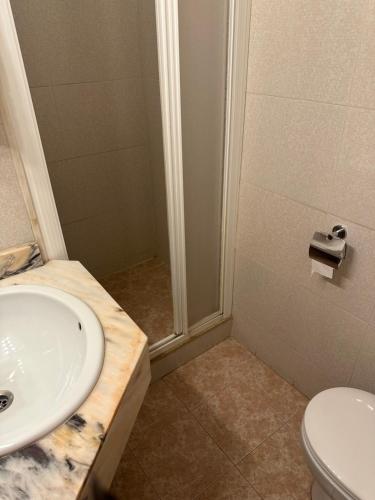 uma casa de banho com um lavatório e um chuveiro em Hostal de la Caravel-la em Cala d´Or