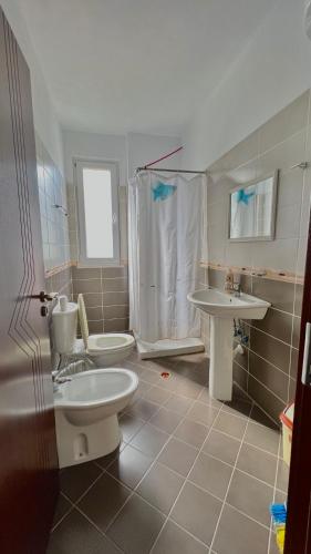 a bathroom with two toilets and a shower and a sink at Queen Residence in Shëngjin