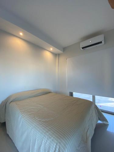 Habitación blanca con cama y ventana en Corrientes Zona Costanera en Corrientes