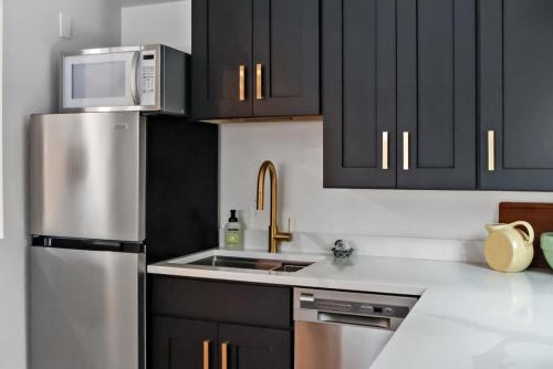 a kitchen with a stainless steel refrigerator and black cabinets at Cozy Hideaway Retreat Unit 4 near Durango in Durango