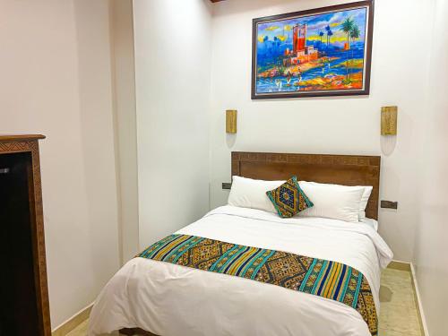 a bedroom with a bed with a painting on the wall at Riad el wazania in Rabat
