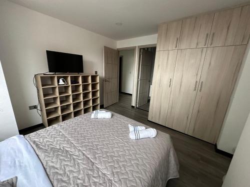 a bedroom with a bed and a flat screen tv at Hermoso apartamento, capacidad 8 personas in Pasto