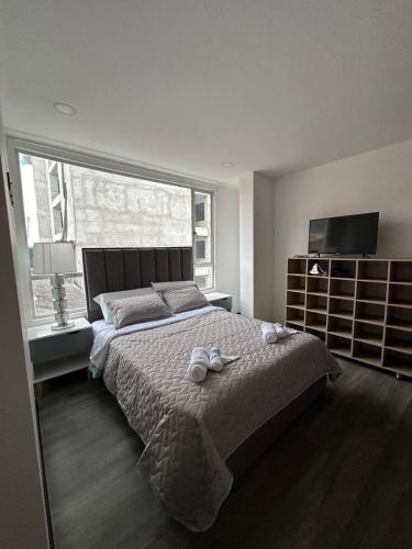a bedroom with a large bed and a large window at Hermoso apartamento, capacidad 8 personas in Pasto