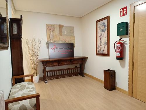 una habitación con una mesa y una boca de incendios en la pared en Habitaciones Javier LVI 0006 en Vitoria-Gasteiz