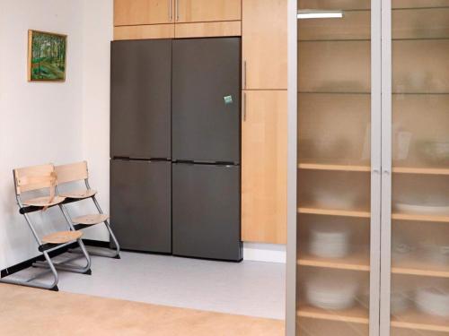 a black refrigerator and a chair in a room at Holiday home VÅXTORP II in Våxtorp