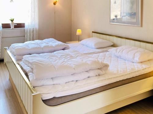 a large white bed with white sheets and pillows at Holiday home Svanesund VI in Svanesund