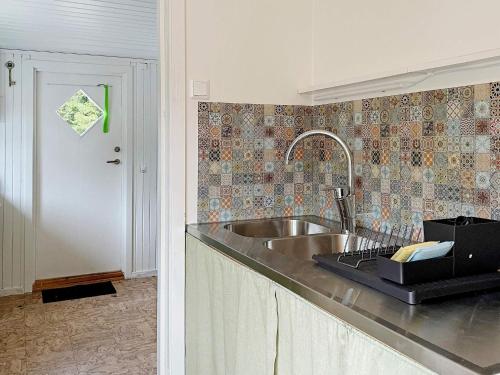 a kitchen with a stainless steel sink and a door at Holiday home Norrtälje IV in Norrtälje