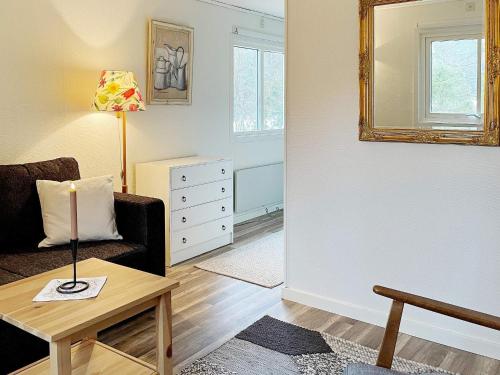 een woonkamer met een bank, een tafel en een spiegel bij Holiday home Norrtälje IV in Norrtälje