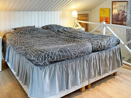 a large bed sitting in a bedroom with a bedskirtspectspectspects at Holiday home BÅSTAD II in Båstad