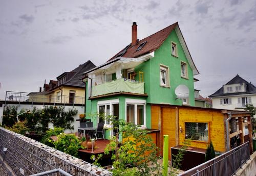 a green and yellow house with a fence at Ferienwohnung Ambiente in Gaggenau