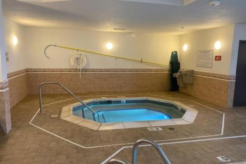 特洛伊的住宿－Troy Inn & Suites，一个带按摩浴缸的大房间,内设网球场