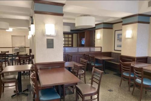 een eetkamer met tafels en stoelen in een kamer bij Troy Inn & Suites in Troy
