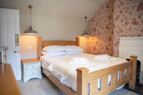 a bedroom with a bed with two towels on it at Gardeners Cottage in Longwitton