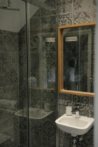 a bathroom with a sink and a glass shower at Gardeners Cottage in Longwitton