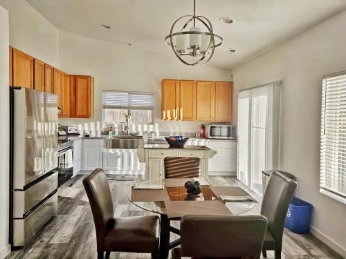 a kitchen with a table and chairs and a refrigerator at Casa Spanaway, an exceptional stay! in Spanaway