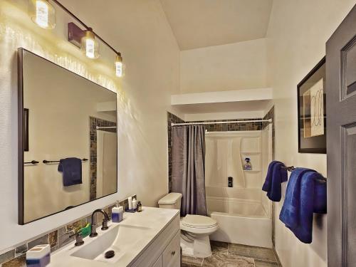 a bathroom with a sink and a toilet and a mirror at Casa Spanaway, an exceptional stay! in Spanaway