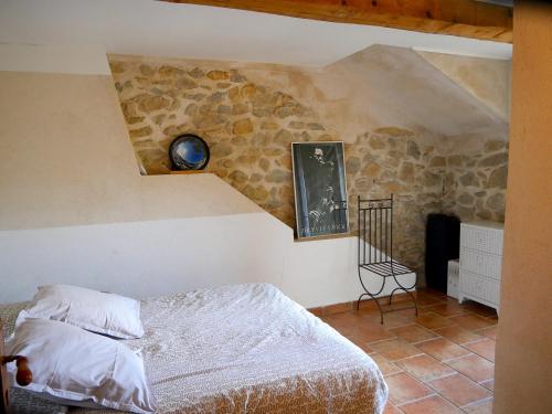 une chambre avec un lit et un mur en pierre dans l'établissement maison-mejean calanque Méjean Côte Bleue Marseille, à Ensuès-la-Redonne