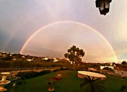 un arco iris doble en el cielo sobre un patio en B&B l'Eucalipto, en Martina Franca