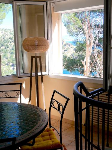 une salle à manger avec une table et des chaises et une fenêtre dans l'établissement maison-mejean calanque Méjean Côte Bleue Marseille, à Ensuès-la-Redonne