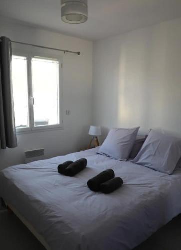 un lit blanc avec deux oreillers dessus dans l'établissement L'Olivier, à Montoison