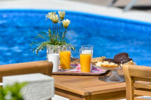 uma mesa com uma bandeja de donuts e sumo de laranja em Apartman za dvoje u villi, privatni wellness, privatni bazen em Črnec Biškupečki