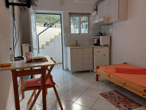 a kitchen with a table and a bed in a room at Ανεξάρτητη γκαρσονιέρα κοντά στο κέντρο της Πάτρας in Patra