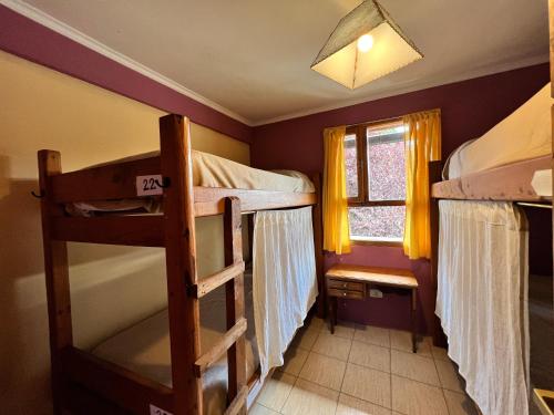 a bedroom with two bunk beds and a window at Ankatu Hostel in El Bolsón