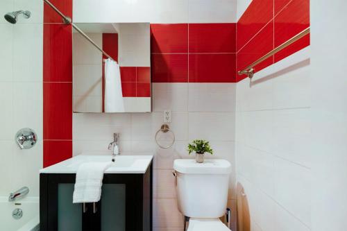 La salle de bains est pourvue de toilettes blanches et d'un lavabo. dans l'établissement 24-4 New Private Terrace W D Apt Prime Gramercy, à New York