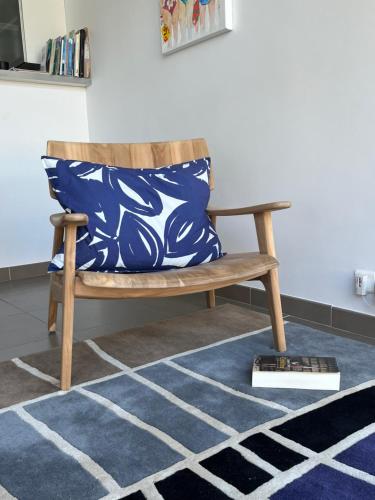 a wooden bench with a blue and white pillow on a rug at LE CAP - bungalow vue mer et colline - Hauteur de Cassis in Cassis