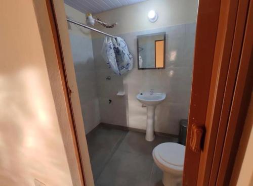a bathroom with a toilet and a sink at Hostal Ña Lali in Villarrica