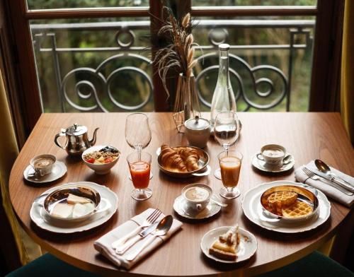 einen Tisch mit Teller mit Speisen und Gläsern Wein in der Unterkunft Hôtel Chateau de Maffliers - Demeures de Campagne in Maffliers