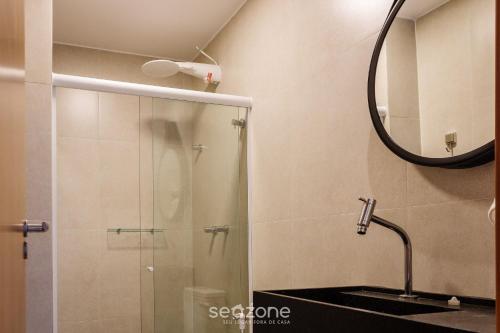 y baño con ducha, lavabo y espejo. en TMH - Condomínio Essence em Porto de Pedras/AL, en Porto de Pedras