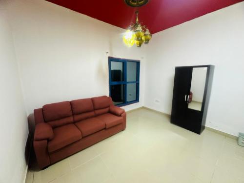 a living room with a couch and a mirror at Modern Comfort Fully Furnished Room for Rent in Ajman 