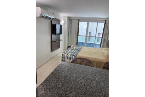 a hotel room with a bed and a television at Blue Sunset in João Pessoa