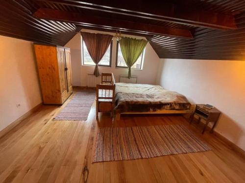 a bedroom with a large bed and a wooden floor at Casa bunicilor/ Grandparent’s house in Zăbala