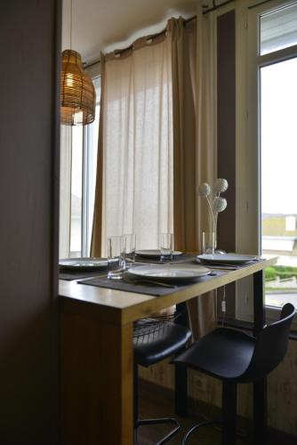 a dining table with two chairs and a window at La Perle Marine superbe vue mer terrasse 30m2 in Criel-sur-Mer