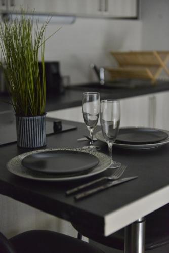 a table with two plates and wine glasses on it at Eldorado, vue mer, terrasse, hypercentre Touquet in Le Touquet-Paris-Plage