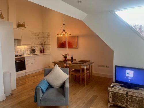 a living room with a chair and a tv and a table at Spacious 1 Bed Flat in London in London