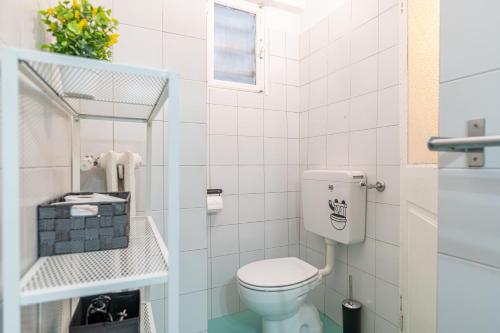 a white bathroom with a toilet and a window at La casa di Levi, in centro a Torino in Turin