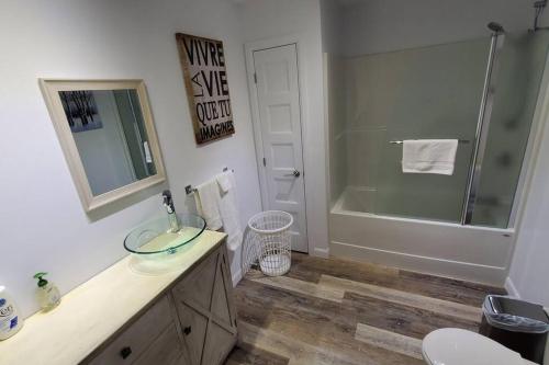 a bathroom with a sink and a shower and a tub at Cottage Quebec - La Nepheline in Petite-Rivière-Saint-François