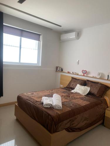 1 dormitorio con 1 cama grande y 2 toallas. en Infinito House 24 en Praia