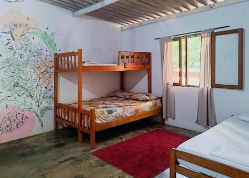 a bedroom with two bunk beds and a window at Palomino EcoHouse & Camping in Palomino