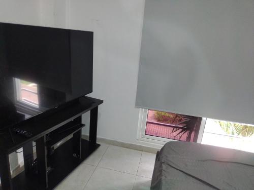 a living room with a flat screen tv next to a window at Oasis Jamundí in Jamundí