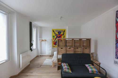 uma sala de estar com um sofá e uma mesa em Pleasant studio in hypercenter em Saint-Denis