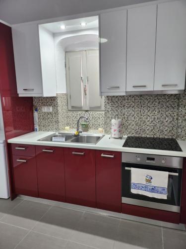 a kitchen with red cabinets and a sink at Mareva's House in Pyrgos