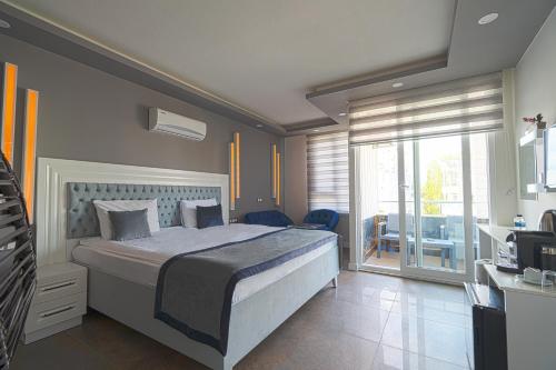 a bedroom with a large bed and a balcony at Mira Hotel Antalya in Antalya