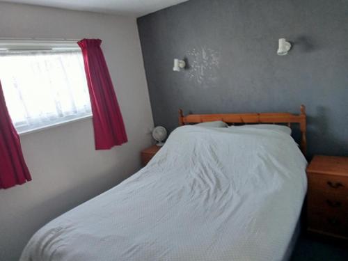 a bedroom with a bed and a window at Cosy 2 Bed chalet Florida Holiday Park, Hemsby in Hemsby